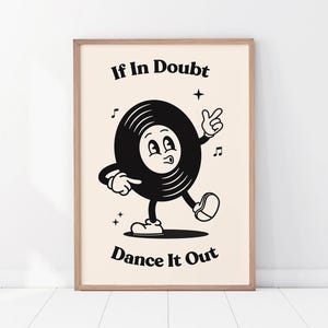 May include: A framed print featuring a cartoon vinyl record character with arms, legs, and a face. The black and white image has the text "If In Doubt Dance It Out" in a retro style font, with musical notes and stars.