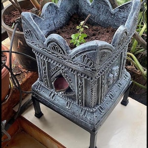 The handmade terracotta Brindavan tulsi pot from TerraVita India has a drainage hole at the bottom and measures 12 inches in height.
