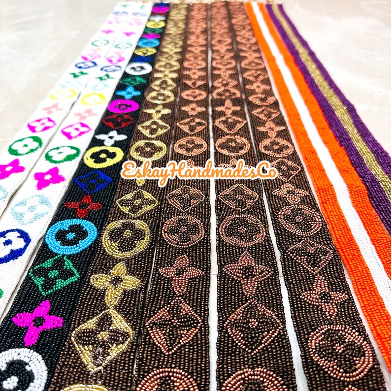 May include: Assortment of beaded trim featuring a repeating pattern of the Louis Vuitton logo in various colours, including white, black, brown, gold, and copper. The trim is made of small beads and is perfect for adding a touch of luxury to any project.