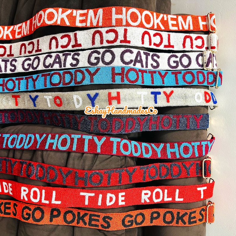 May include: A collection of colourful beaded belts with various phrases, including "Hook 'em", "Cats Go", "Hotty Toddy", "Roll Tide", and "Pokes Go".