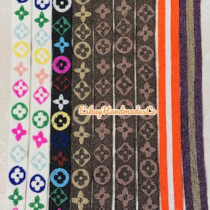 May include: Assortment of beaded trim featuring a repeating pattern of the Louis Vuitton logo in various colours, including white, black, brown, and orange. The trim is approximately 2.5 cm wide and is perfect for adding a touch of luxury to any project.