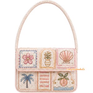 Op de afbeelding: Een kralen handtas met een lichtroze handvat en basis. De tas heeft geborduurde panelen met een bloem, een plant in een vaas, een zeeschelp, een palmboom, een gebouw en een perzik. De tekst "Eskay HandmadesCo" is zichtbaar.