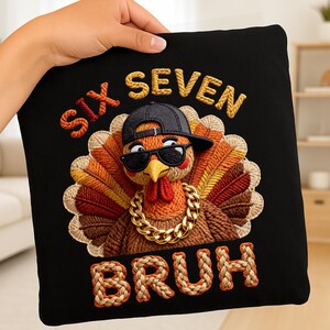 May include: Black square pillow with an embroidered turkey wearing sunglasses, a backward baseball cap, and a gold chain. The words "SIX SEVEN BRUH" are embroidered in orange and tan thread.