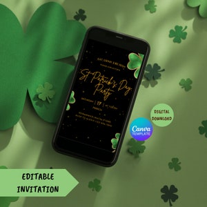 May include: A smartphone displays a St. Patrick's Day party invitation with gold text and shamrock accents. The phone is surrounded by green shamrock cutouts on a green surface. The invitation includes the text "Eat, Drink & Be Irish."