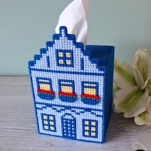 Könnte beinhalten: Blaue und weiße Tissuebox-Abdeckung in Form eines Hauses mit roten Blumenkästen und gelben Fenstern.