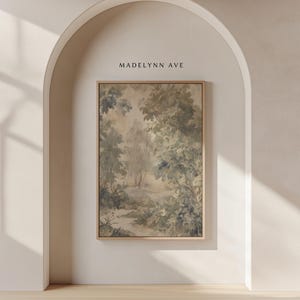 May include: A framed landscape art print featuring a serene forest scene in muted green and beige tones. The artwork depicts trees, a path, and soft light, with the text "MADELYNN AVE" at the top.