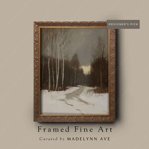 May include: Framed fine art print of a winter landscape with a snow-covered path leading into a forest. The artwork is in a decorative gold frame. The text "DESIGNER'S PICK" is in the upper right corner.