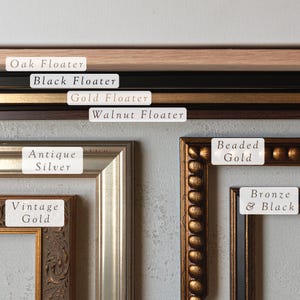 May include: A variety of picture frames in different colors and styles, including oak, black, gold, walnut, antique silver, vintage gold, beaded gold, and bronze and black.