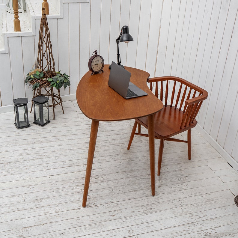 Enhance your workspace with this elegant ellipse desk table, designed to bring style and function together. Ideal as a wood laptop table or small writing desk, its boomerang desk table silhouette adds a midcentury charm. Crafted from quality walnut, this midcentury wood desk doubles as a mid century table and a practical computer desk table. Whether used as a home office desk, modern wooden desk, or walnut writing desk, it fits seamlessly into any interior.