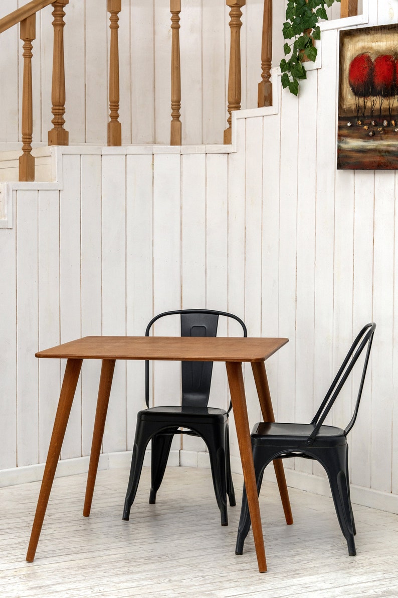 Here is Square Walnut Wooden Dining Room Table! This Narrow Space Dine Table Kitchen in the dining room perfectly complements and change the cozy small home atmosphere, offering a personalized touch to the kitchen.
