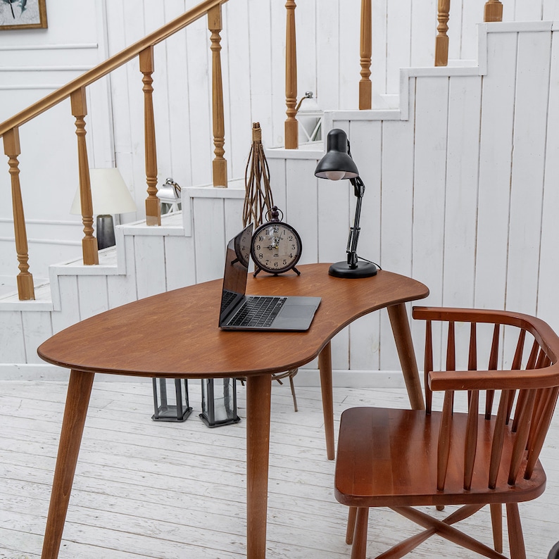 Enhance your workspace with this elegant ellipse desk table, designed to bring style and function together. Ideal as a wood laptop table or small writing desk, its boomerang desk table silhouette adds a midcentury charm. Crafted from quality walnut, this midcentury wood desk doubles as a mid century table and a practical computer desk table. Whether used as a home office desk, modern wooden desk, or walnut writing desk, it fits seamlessly into any interior.