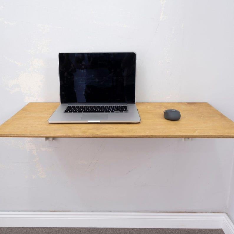 Here is Wall Mounted Foldable Home Office Desk Table! This Fold Down Small Space Saving Laptop Desk in the home office, balcony or kitchen perfectly complements the cozy atmosphere, offering a personalized touch to the workspace.