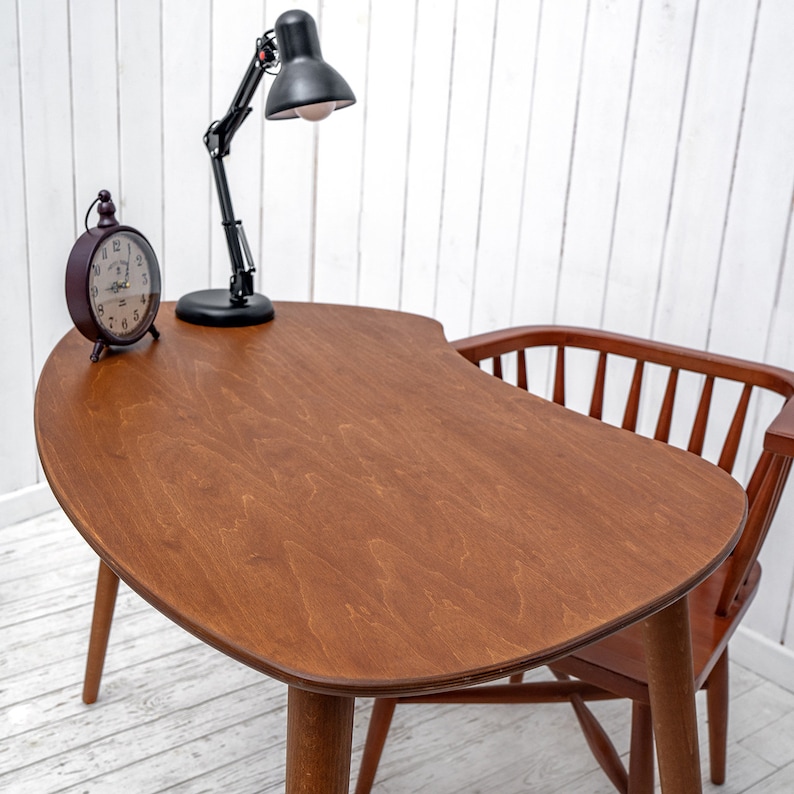 Enhance your workspace with this elegant ellipse desk table, designed to bring style and function together. Ideal as a wood laptop table or small writing desk, its boomerang desk table silhouette adds a midcentury charm. Crafted from quality walnut, this midcentury wood desk doubles as a mid century table and a practical computer desk table. Whether used as a home office desk, modern wooden desk, or walnut writing desk, it fits seamlessly into any interior.