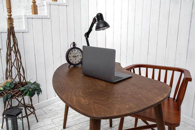 Enhance your workspace with this elegant ellipse desk table, designed to bring style and function together. Ideal as a wood laptop table or small writing desk, its boomerang desk table silhouette adds a midcentury charm. Crafted from quality walnut, this midcentury wood desk doubles as a mid century table and a practical computer desk table. Whether used as a home office desk, modern wooden desk, or walnut writing desk, it fits seamlessly into any interior.