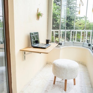 Here is Wall Mounted Foldable Home Office Desk Table! This Fold Down Small Space Saving Laptop Desk in the home office, balcony or kitchen perfectly complements the cozy atmosphere, offering a personalized touch to the workspace.