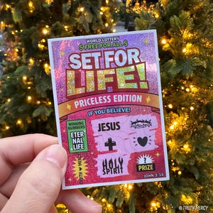 May include: A pink and purple scratch-off lottery ticket with the text "SET FOR LIFE!" and the words "PRICELESS EDITION." The ticket features religious symbols and the text "JESUS" and "HOLY SPIRIT."