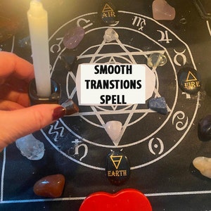 Peut inclure: Un tissu noir avec un pentagramme et les mots "Smooth Transitions Spell" écrits sur une carte blanche. Différents cristaux et pierres sont disposés autour du pentagramme, notamment du quartz clair, du quartz rose, de l'améthyste et une bougie blanche allumée.