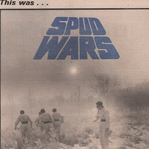 Op de afbeelding: Een zwart-witfoto van een band die op het podium optreedt. De band heet Devo en ze dragen bijpassende zilveren jumpsuits. De foto is afkomstig uit een artikel in het New Musical Express magazine uit 1978.