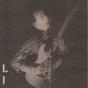 Op de afbeelding: Een zwart-witfoto van een muzikant die gitaar speelt op een podium. De tekst "Your Policemen Are Really Wonderful" staat boven de foto. De tekst "60s & 70s Music-Fan" staat onder de foto. De tekst "Pity About Some Of The Others" staat onder de tekst "60s & 70s Music-Fan".