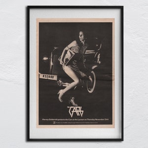 May include: Black and white photo of a woman in a leopard print dress sitting on a vintage car. The car has a license plate that reads "K 52088". The text "Harvey Goldsmid presents the Cars at the Lyceum on Thursday November 21st" is at the bottom of the image.