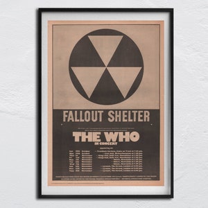 Könnte beinhalten: Gerahmtes Vintage-Konzertplakat für The Who, mit einem schwarz-weißen Atom-Symbol. Das Plakat trägt den Titel "Fallout Shelter" und listet Konzertdaten und Veranstaltungsorte in Großbritannien auf. Der Rahmen ist schwarz.