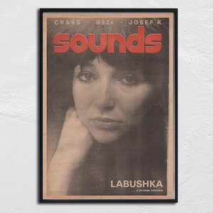 May include: A framed vintage magazine cover featuring a black and white portrait of a woman. The word "sounds" is in large red letters. Text at the top reads "Crass B52s Josef K" and at the bottom "LABUSHKA...a six-page interview."