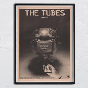 Könnte beinhalten: Ein Schwarzweiß-Poster für die Band The Tubes. Das Poster zeigt ein roboterartiges Objekt mit einem Bildschirm, auf dem "Remote Control" steht. Das Poster enthält auch den Text "New Album" und "Produziert und aufgenommen von Todd Rundgren".