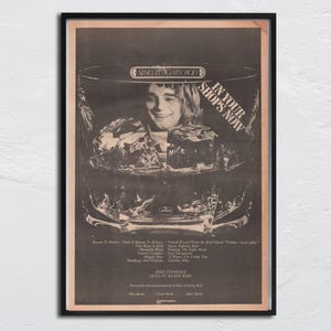 Puede incluir: Anuncio vintage enmarcado con Rod Stewart dentro de un vaso con hielo. El texto "SING IT AGAIN ROD" está en la parte superior, con "IN YOUR SHOPS NOW" en la parte superior derecha. Títulos de canciones y el nombre de Rod Stewart en la parte inferior.