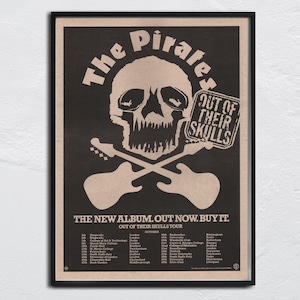 Può includere: Poster nero e beige con un teschio, chitarre incrociate e la scritta "The Pirates". Il poster promuove l'album "Out of Their Skulls" e le date del tour. Il poster è incorniciato in una cornice nera.