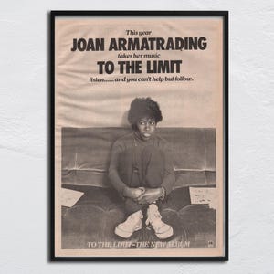 May include: A framed vintage poster featuring Joan Armatrading. The poster has a black frame and a sepia-toned background. The text reads "JOAN ARMATRADING TO THE LIMIT." A photo of Armatrading is in the center, seated on a couch. The album title is at the bottom.