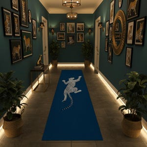 Peut inclure: Un long tapis de couloir rectangulaire bleu orné d'un motif de léopard blanc à taches noires au centre. Le tapis est posé sur un sol carrelé dans un couloir aux murs bleu sarcelle foncé décorés de nombreux cadres représentant des léopards.