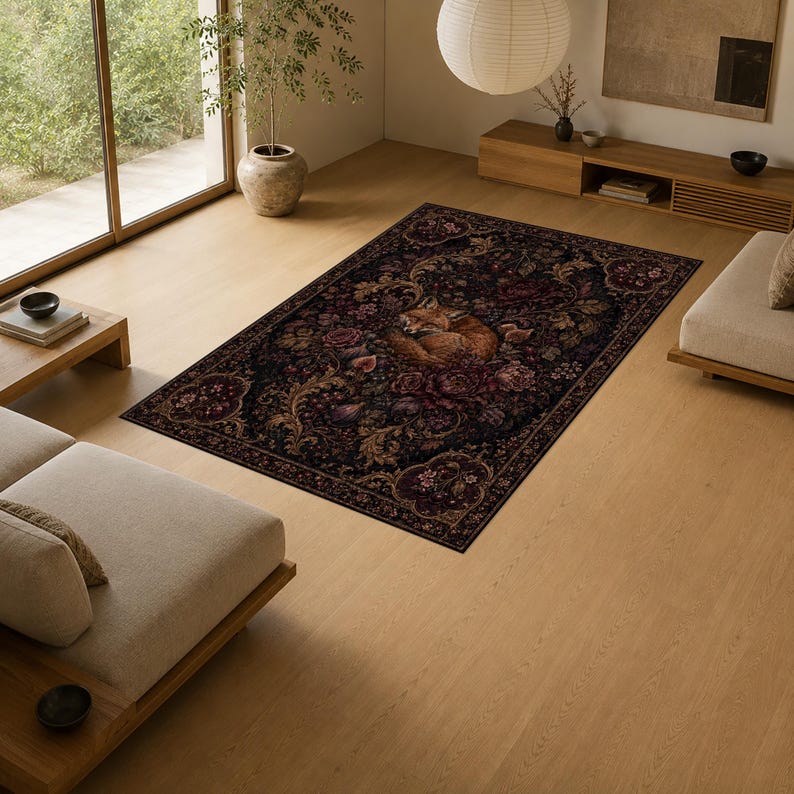 Puede incluir: Una alfombra rectangular con un fondo oscuro y evocador, con intrincados patrones florales en tonos rojo intenso, dorado y marr&oacute;n. Una ilustraci&oacute;n central muestra a un zorro enroscado rodeado de motivos bot&aacute;nicos detallados y follaje.