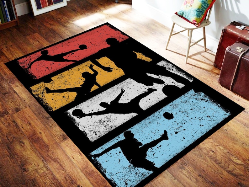 May include: A black and white rug with a retro design featuring five silhouettes of soccer players kicking a ball. The rug has a distressed look with a faded color scheme of red, yellow, white, and blue.
