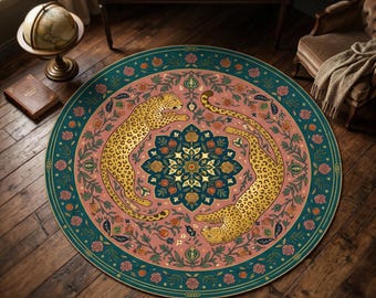 Puede incluir: Una alfombra circular con dos leopardos dorados en disposición de espejo sobre un fondo rosa empolvado. El centro muestra un mandala floral azul oscuro, mientras que el borde exterior es de color verde azulado profundo con rosas.