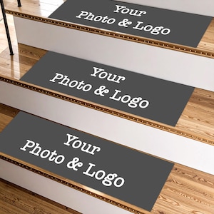 Può includere: Tre gradini di scale grigio scuro con la scritta "Your Photo & Logo" in bianco. I gradini sono su scale di legno con alzatine bianche. L'immagine mostra un primo piano delle scale.