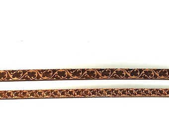 May include: Two wooden strips with a repeating carved floral pattern. The strips are a warm brown colour and are set against a white background. The design is detailed and symmetrical, suitable for craft projects.