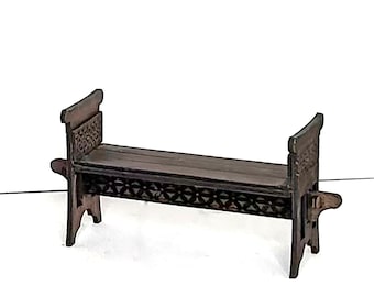 May include: A dark brown wooden bench with intricate carved details on the sides and a simple rectangular seat.