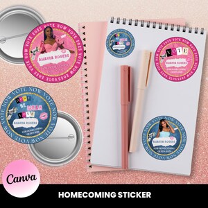 May include: A collection of homecoming-themed stickers and buttons. The stickers and buttons feature the text "Vote Now 2025" and "Amanda Rogers For Homecoming Queen 2025". A pink notebook and pens are also visible.