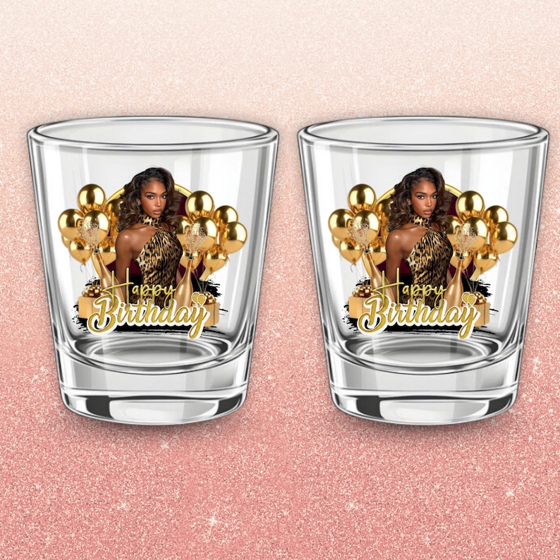May include: Two clear shot glasses with a gold and black design. Each glass features a woman in a leopard print dress, gold balloons, and the words "Happy Birthday" in gold script.