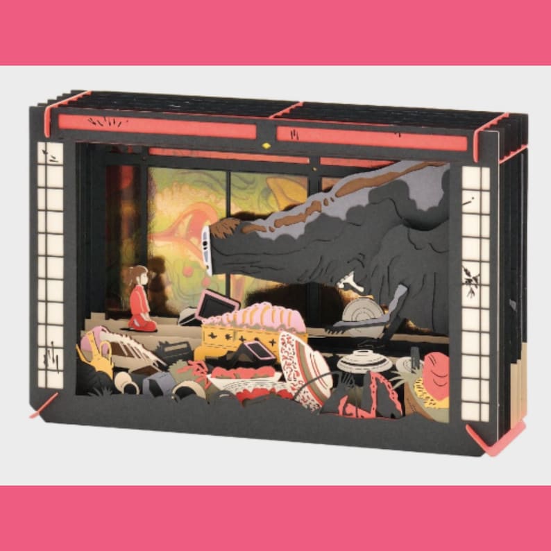 May include: A multi-layered paper diorama depicting a scene from an animated film. The diorama features a red-clad figure, a large creature, and various objects within a Japanese-style setting. The structure is framed with black and red accents.