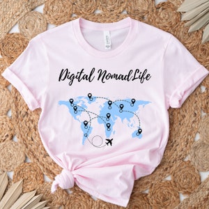 May include: Pink t-shirt with a black graphic of a world map with pins and a plane, and the text "Digital Nomad Life".