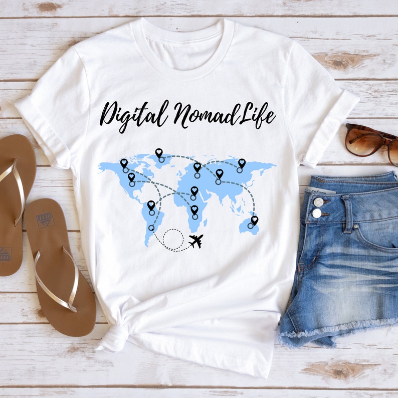 May include: White t-shirt with a blue world map and the text "Digital Nomad Life". The map has black pins and a black airplane.