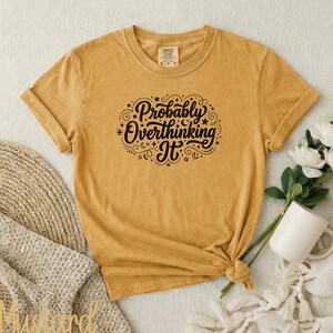 Pode incluir: Um conjunto de três canecas de cerâmica com esmalte creme salpicado. Cada caneca apresenta um design floral pintado à mão em tons de azul, verde e amarelo. As canecas têm uma forma simples e arredondada.