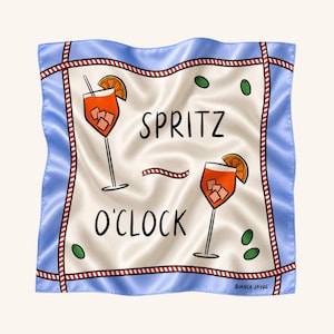 May include: A square silk scarf with a cream center featuring two orange spritz cocktails, green olives, and the text SPRITZ O'CLOCK. The border is light blue with a red and white striped trim. The brand name BIANCA JAYDE is printed in the corner.