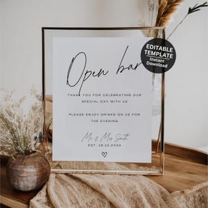 Puede incluir: Un letrero blanco enmarcado en vidrio transparente muestra en escritura negra "Open bar". El letrero incluye texto para una celebración, con los nombres "Mr & Mrs Smith" y la fecha "EST. 16.12.2024". Se incluye un pequeño corazón.