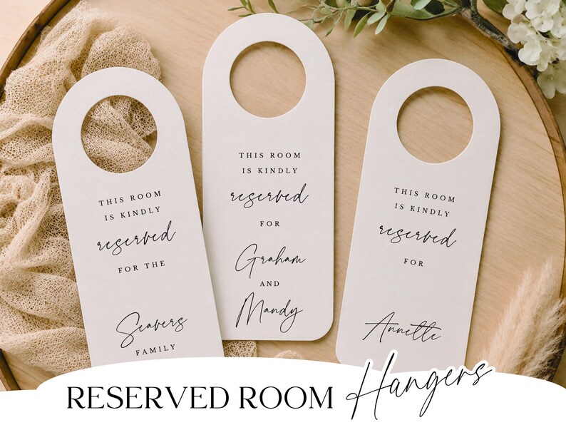 May include: Three white reserved room hangers with a rounded top and a hole for the door handle. Each hanger has the words "This room is kindly reserved for" printed in black, with a family name or couple's names below.