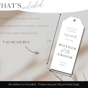 May include: A white tag with the text "THIS SEAT IS KINDLY reserved FOR THE MOTHER of the GROOM" and the names Sylvia Kerry. The tag measures 7.5 inches long and 3 inches wide. The text is printed in black ink.