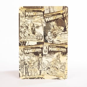 May include: A rectangular Star Wars themed notebook featuring comic book covers of The Mandalorian. The covers are in black and white and include text such as "Mando at Gunpoint!" and "The Prisoner".