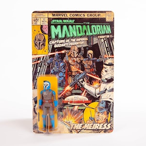 May include: A Star Wars: The Mandalorian action figure on a vintage comic book-style card. The card features comic book art with the title "The Mandalorian" and the text "Capture of the Imperial Gozanti Freighter!" The figure is blue, gray, and brown.