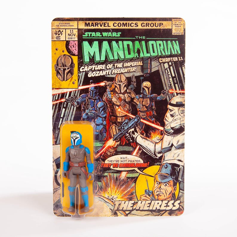 May include: A Star Wars: The Mandalorian action figure on a vintage comic book-style card. The card features comic book art with the title "The Mandalorian" and the text "Capture of the Imperial Gozanti Freighter!" The figure is blue, gray, and brown.
